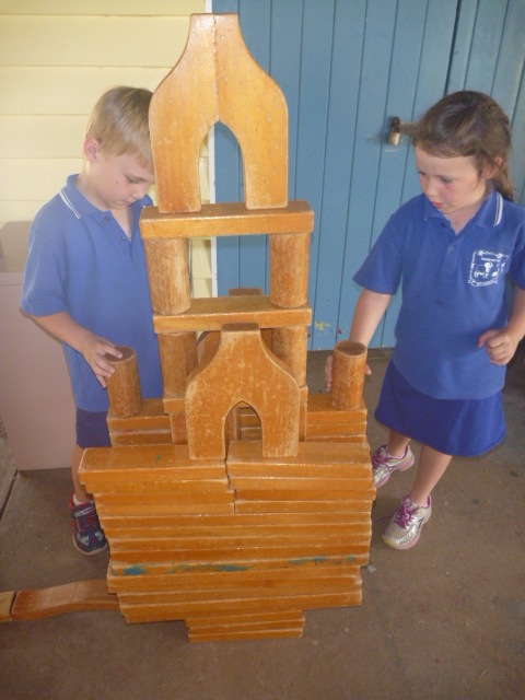 Two students working on a wooden tower